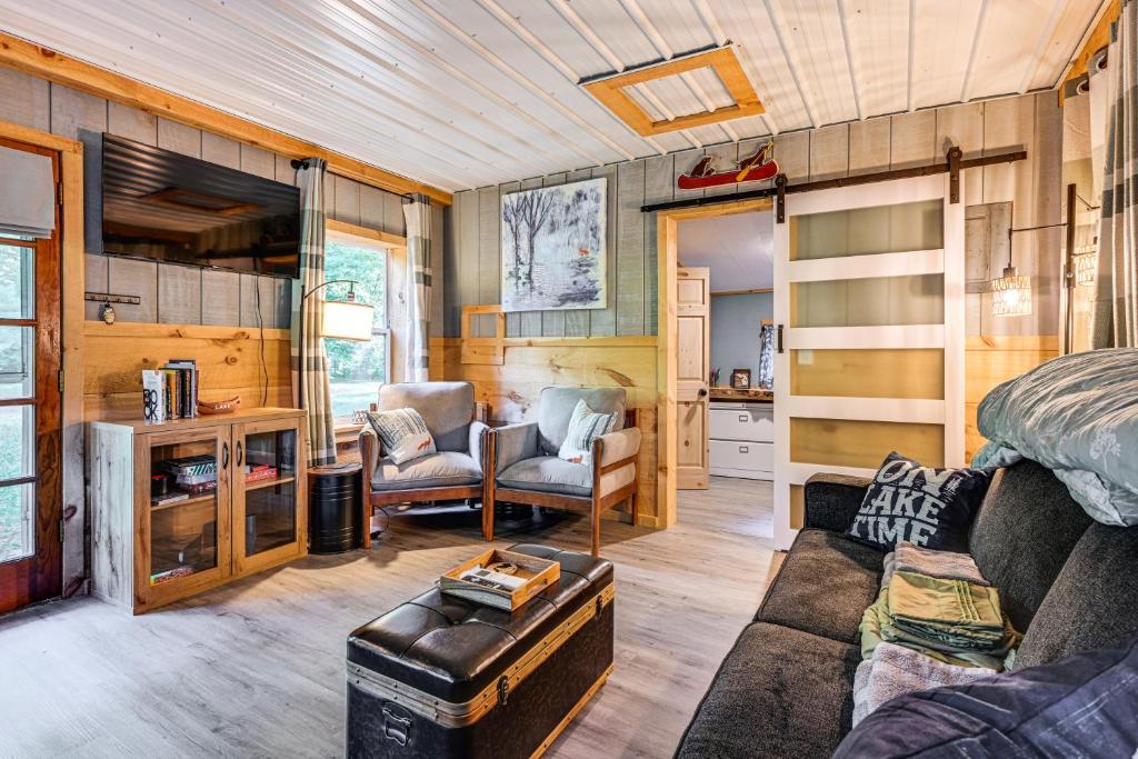 a living room with a bed and a couch at Lake Access and Kayaks Gladwin Cottage Near Golfing in Gladwin