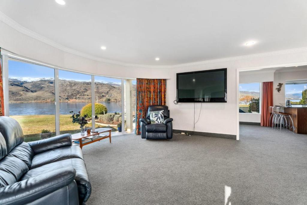 a living room with a couch and a flat screen tv at Mount Pisa Lake View in Cromwell