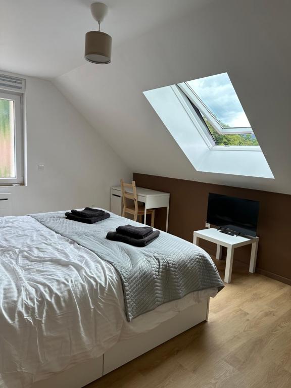 a white bedroom with a bed and a skylight at Horizons du Haut in Niederbronn-les-Bains