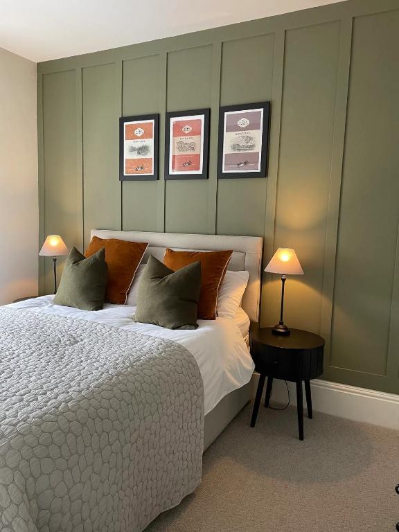 a bedroom with a bed and two pictures on the wall at 4 Beckside Cottage in Windermere
