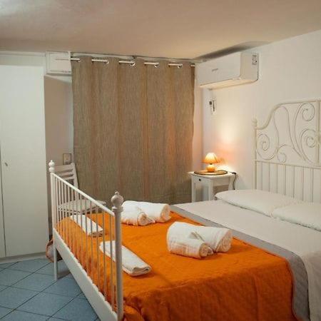a bedroom with two beds and an orange blanket at Domus Lord Byron in Formia