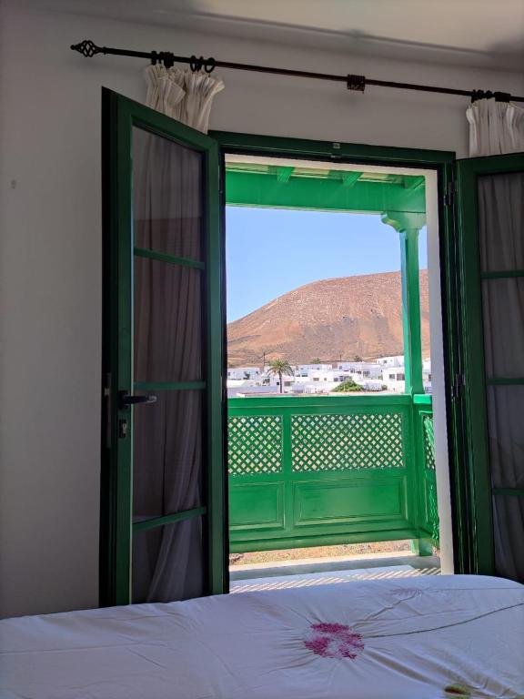 a bedroom with a bed and a green door with a view at Montaña de Uga in Uga