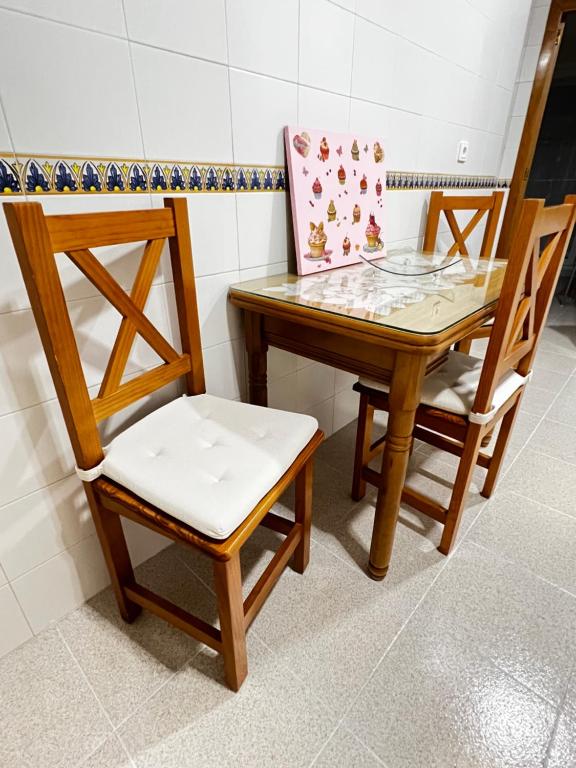 a table with two chairs and a table with a box on it at Vivienda Cádiz in Cádiz