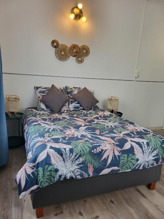 une chambre avec un lit avec une couette colorée dans l'établissement Calme - Wifi - Netflix - Stationnement gratuit, à Lens