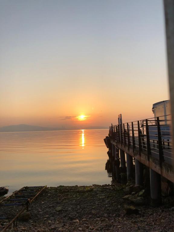 un tramonto sull'acqua accanto a un molo di Kınalı adada full manzaralı güzel teraslı yazlık a Adalar