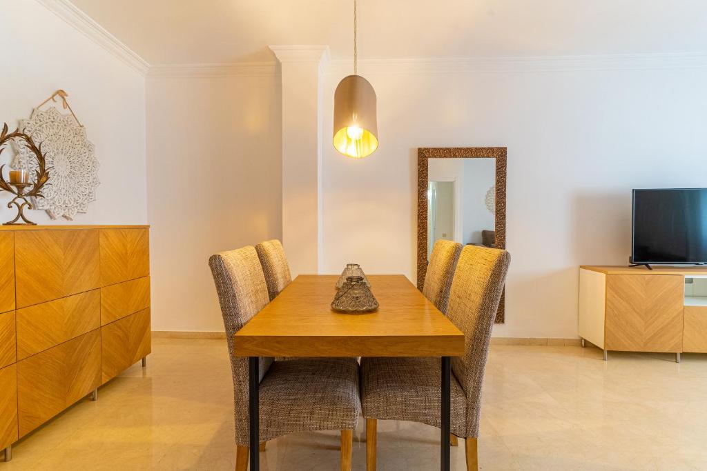 a dining room with a table and chairs and a mirror at TrendyHomes City Center in Almería