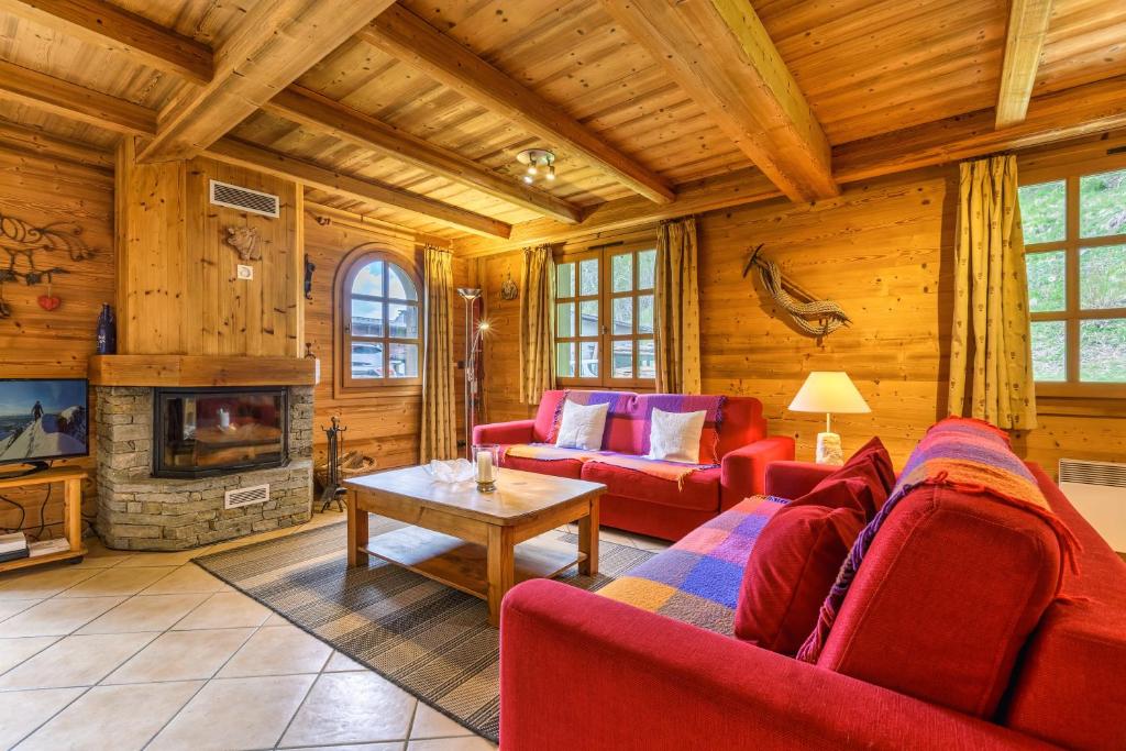 un salon avec des meubles rouges et une cheminée dans l'établissement Chalets d'Henri 67 - Happy Rentals, à Chamonix-Mont-Blanc