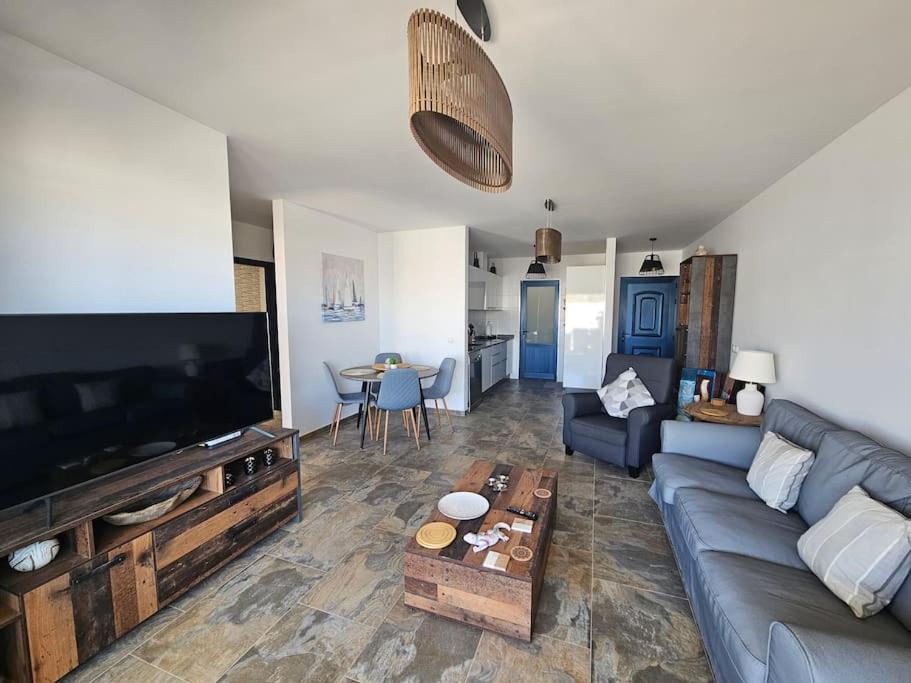 a living room with a couch and a large flat screen tv at Luna Azul in Playa Blanca