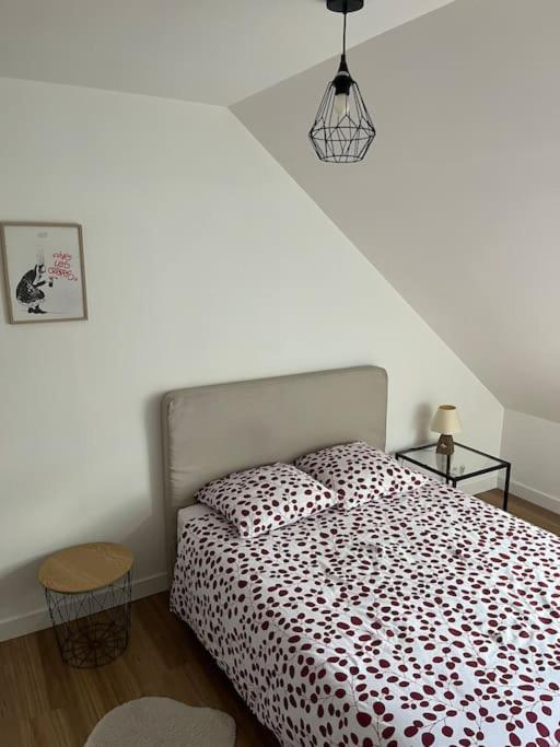 une chambre avec un lit avec une couette noire et blanche dans l'établissement Charmant T2 Landivisiau, à Landivisiau