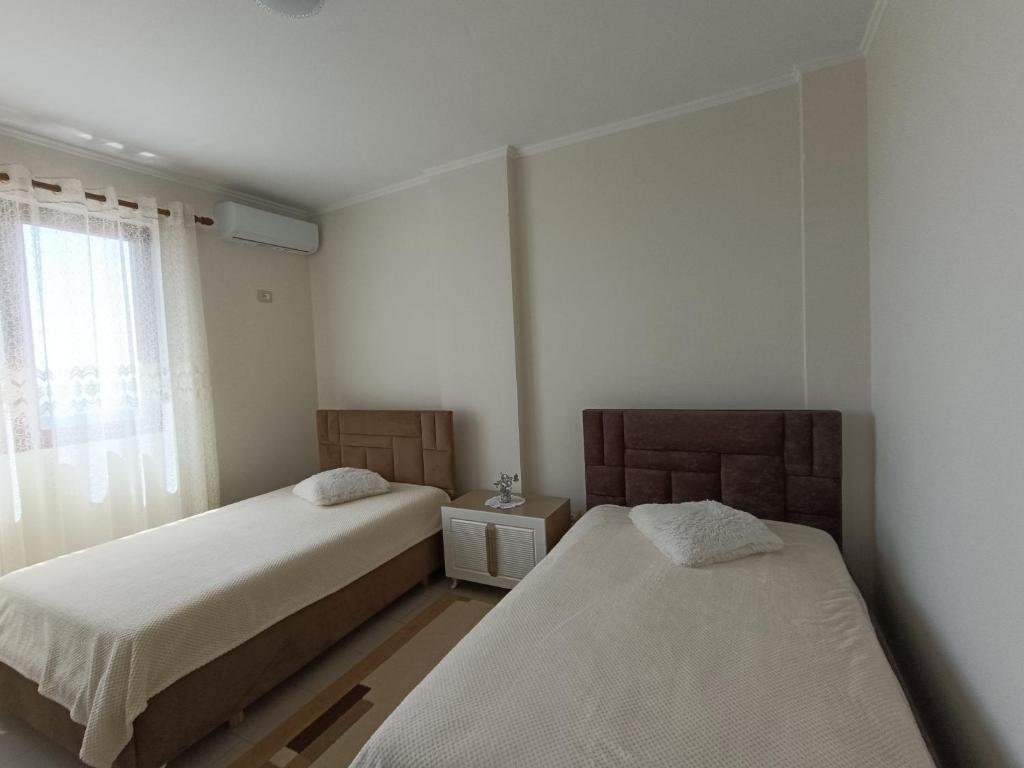 克鲁亚Panoramic Krujë Escape BAMI的有两张床和一扇窗户的卧室