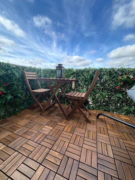 une table et une chaise en bois assises sur une terrasse dans l'établissement Cosy avec terrasse à Disney, à Montévrain