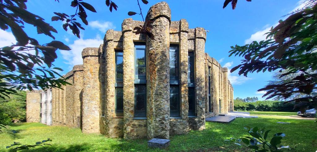 an old castle with columns on the grass at AG Casa O Remanso de Pedreira con finca 20000 m in Carballo