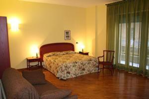 um quarto com uma cama e uma sala de estar com um sofá em Hotel Morfeo Residence em Siracusa