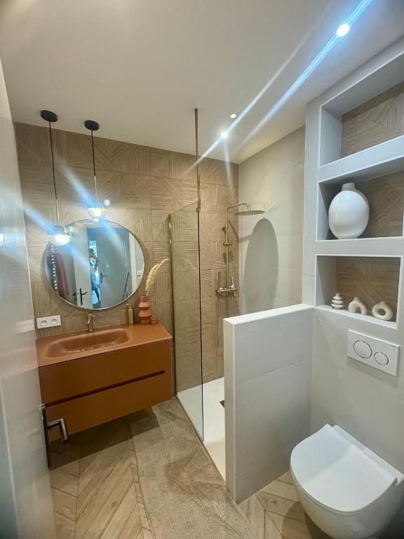 une salle de bain avec toilettes, lavabo et miroir dans l'établissement le somptueux, à Antibes