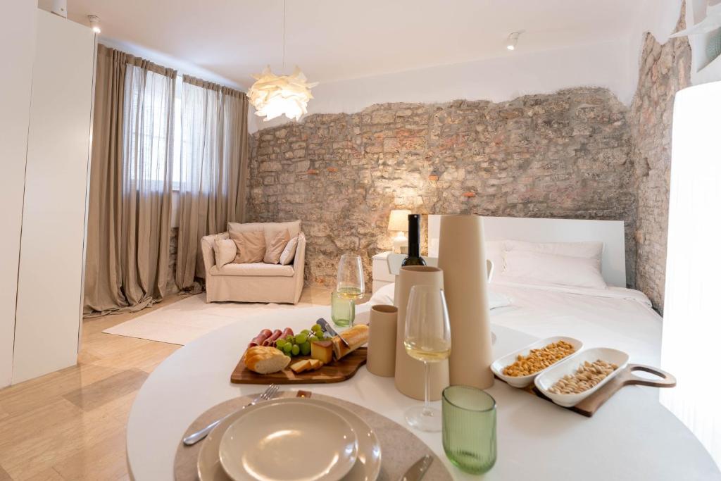 a room with a bed and a tray of food on a table at Konzul Apartment in Pula