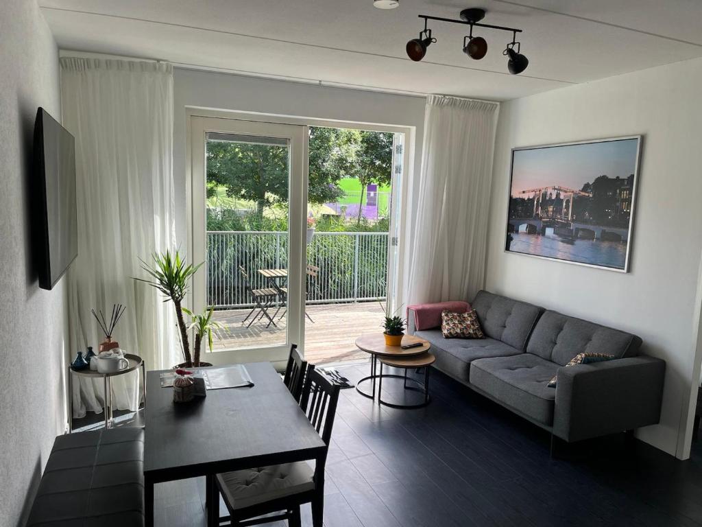 una sala de estar con un sofá y una mesa en In Almere, Close to Amsterdam, en Almere