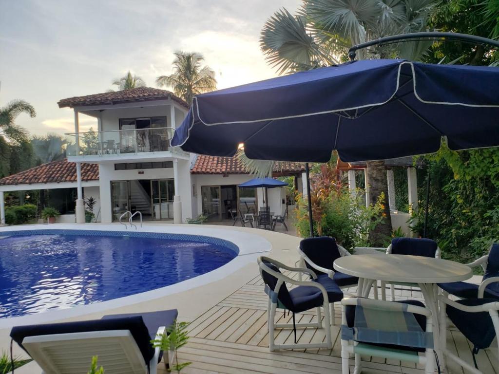 a house with a swimming pool and a table with an umbrella at Casa Pinilla- Perfecta para Paseos in Ricaurte