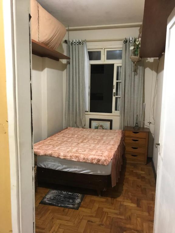 a small bedroom with a bed and a window at Quarto Privativo - Pitangueiras - 50mts da Praia in Guarujá