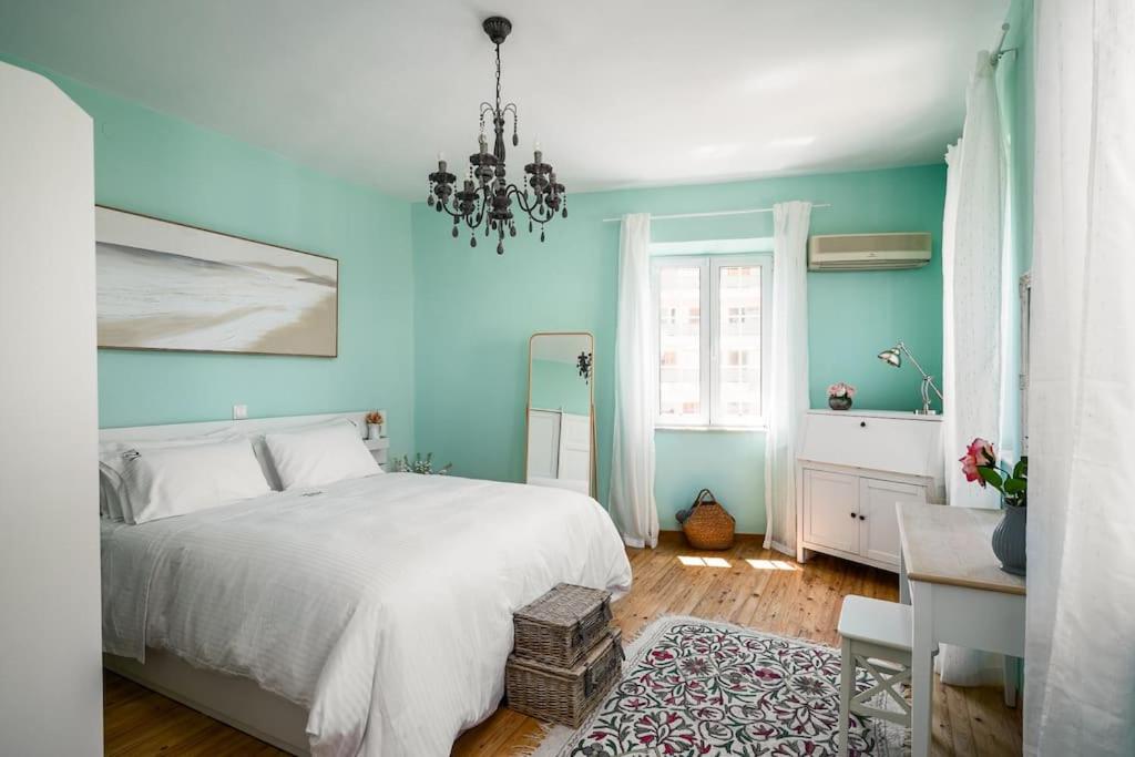 a blue bedroom with a bed and a chandelier at Infinite Residences - Central Location, Tradition and Comfort in Corfu Town