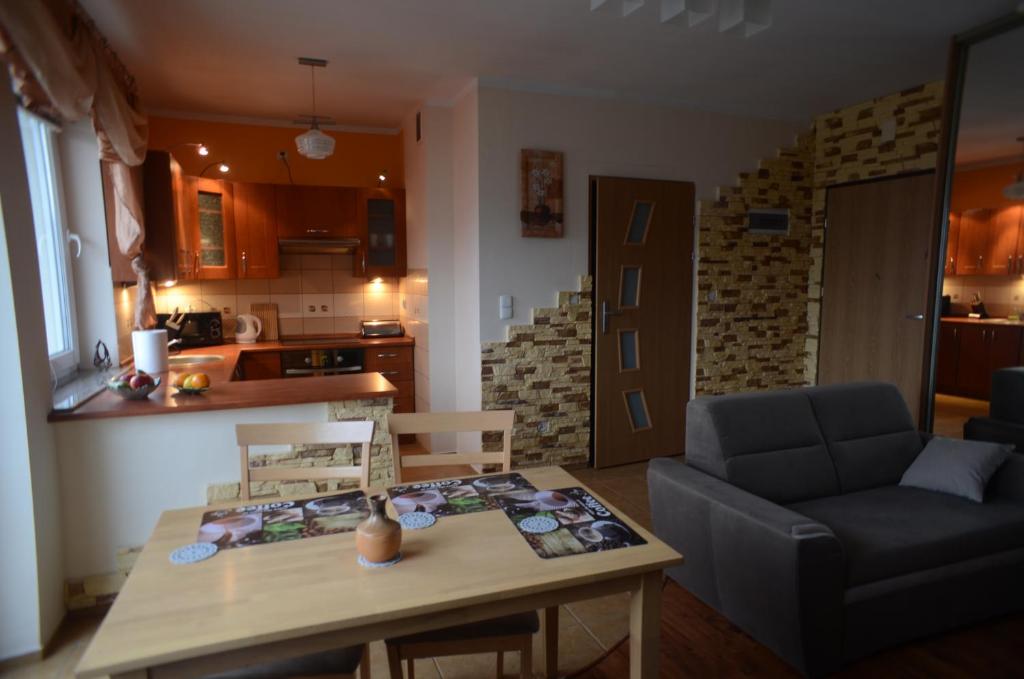 a living room with a table and a couch at Apartament Classic in Szczecin