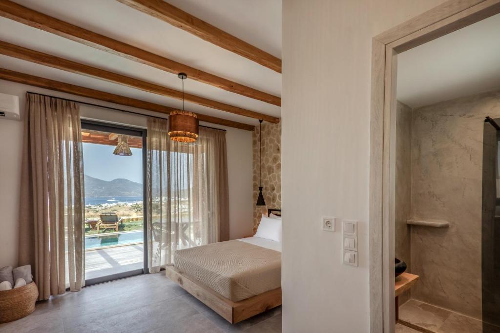 Postel nebo postele na pokoji v ubytování Obsidian Suites Milos
