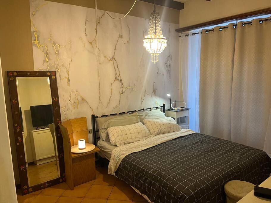 a bedroom with a bed and a mirror and a chandelier at Benedetta in Chiavenna