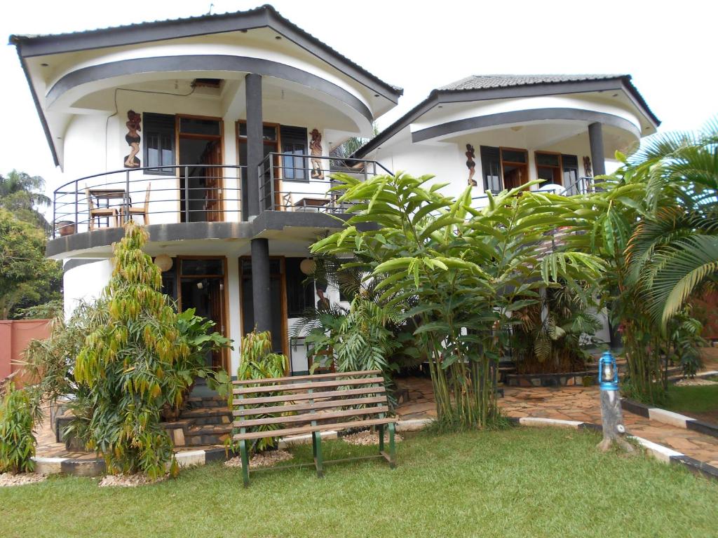 a house with a bench in front of it at Chel & Vade Hotel in Jinja