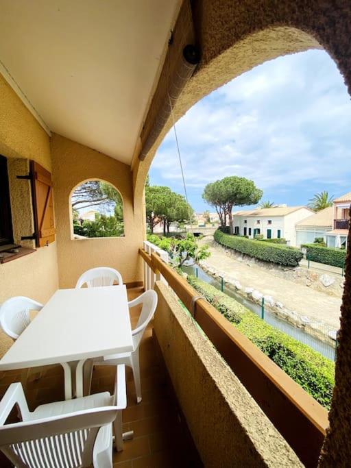 d'un balcon avec une table et des chaises offrant une vue sur la rue. dans l'établissement Appartement mezzanine au bord de la lagune, à Saint-Cyprien