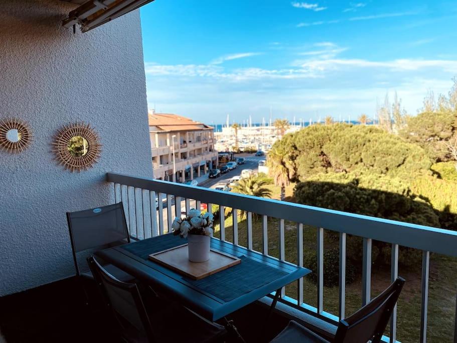 une table bleue et des chaises sur un balcon dans l'établissement Élégant appartement au Port de Saint-Cyprien, à Saint-Cyprien