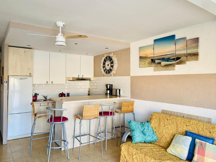 un salon avec un canapé et une cuisine dans l'établissement Grand appartement proche du Port, à Saint-Cyprien