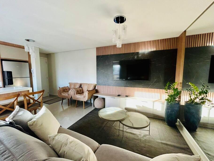 un salon avec un canapé et une télévision dans l'établissement Apartamento novo em Foz, ao lado do Shopping JL, à Foz do Iguaçu