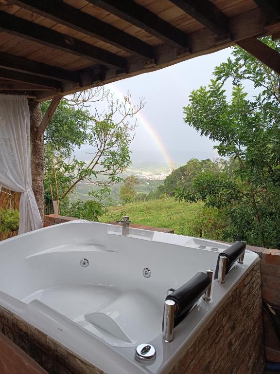 una vasca da bagno con arcobaleno sullo sfondo di Glamping el nido a Curití