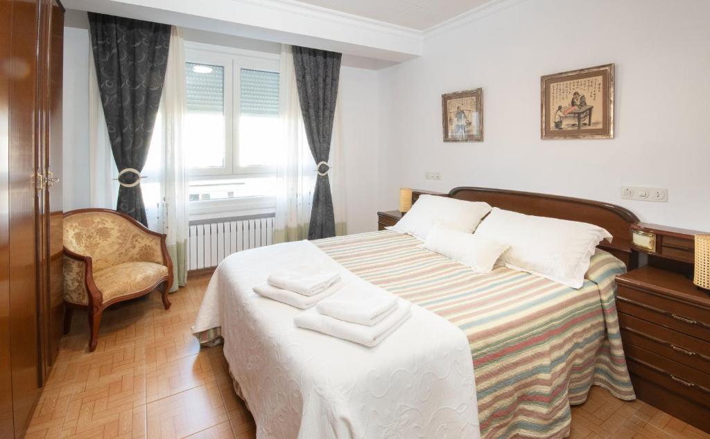 a bedroom with a bed with two towels on it at AG Piso Isabema a 400m del centro de Carballo in Carballo