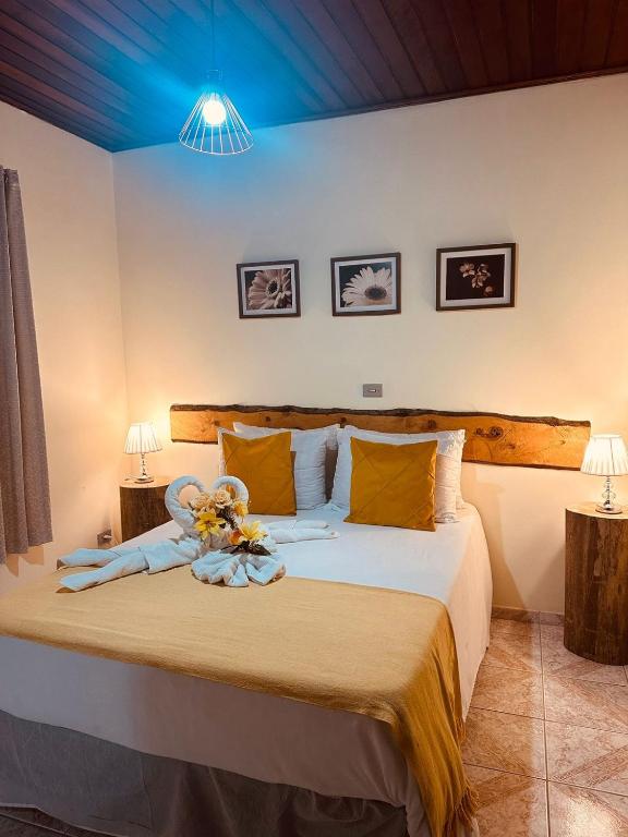 um quarto com uma cama com um ursinho de pelúcia em Pousada Valle do Sol em Campos de Jordão