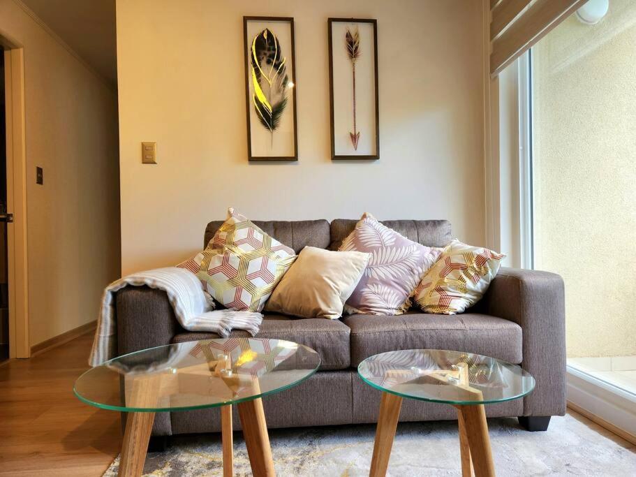 a living room with a couch and two glass tables at Departamento equipado Parque Oriente in Temuco