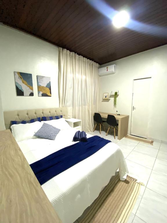 a bedroom with a large bed and a desk at Charmoso Studio, em Castanhal in Castanhal