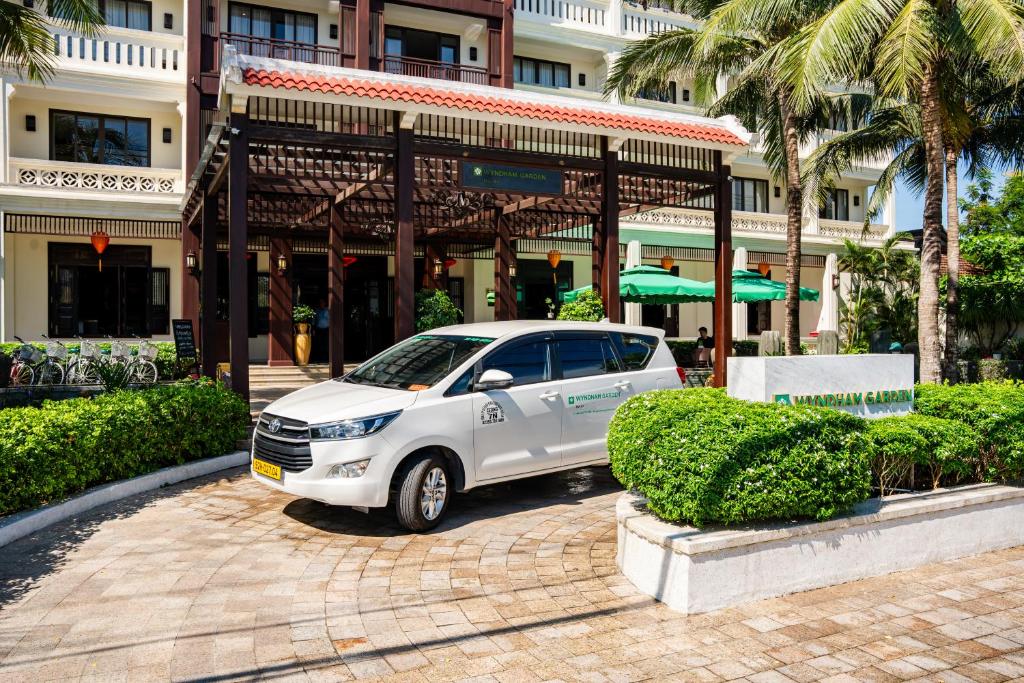 a white car parked in front of a building at Wyndham Garden Hoi An Cua Dai Beach in Hoi An