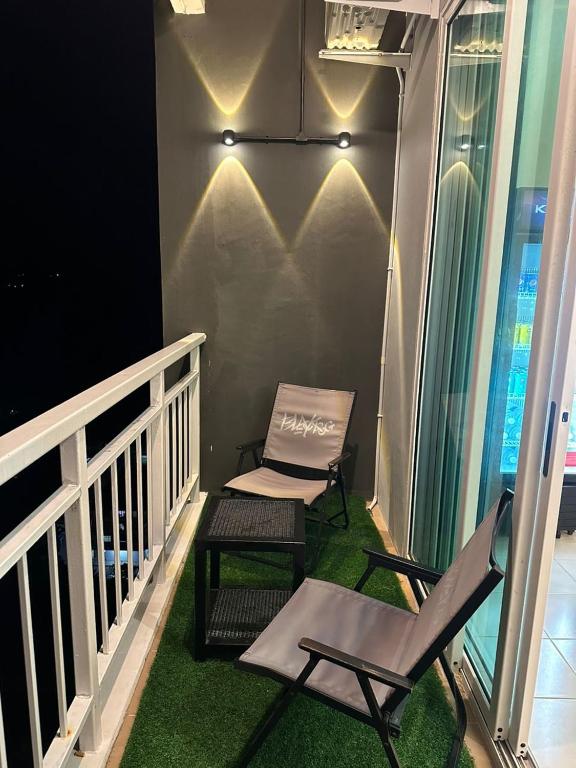 a balcony with two chairs and a table and a chair at The Cove Homestay Sandakan - seaview in Sandakan