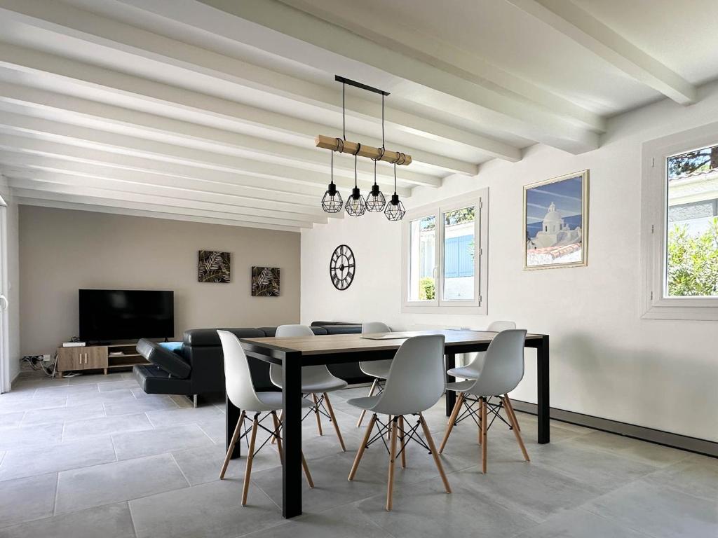 un salon avec une table et des chaises de salle à manger dans l'établissement Villa rénovée à La Palmyre pour 6 pers. - Patio, wifi, proche plage et commerces - FR-1-705-85, aux Mathes
