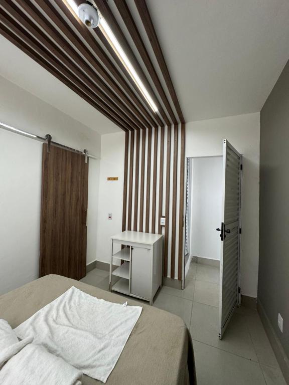 Un dormitorio con una cama y una mesa dentro. en Flat indians Parque das nacoes indigenas, en Cuiabá