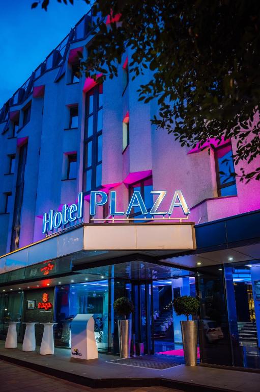 una plaza del hotel está iluminada por la noche en Plaza V Hotel, en Târgu Mureș