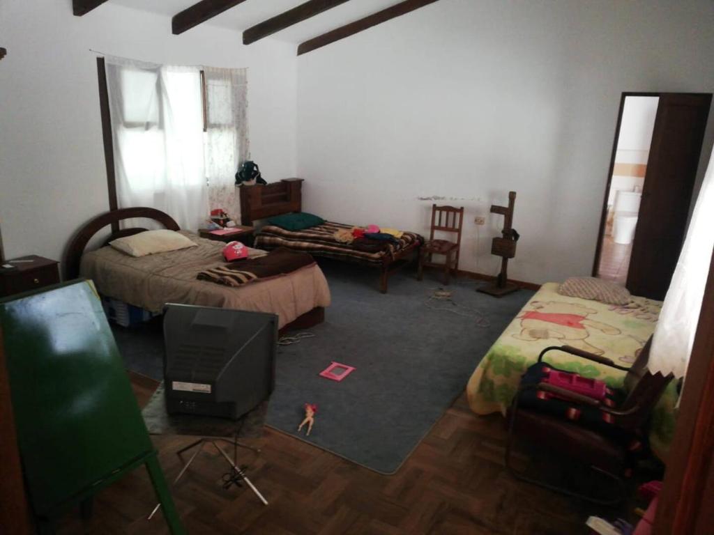 Zimmer mit 2 Betten und einem TV. in der Unterkunft Casa en el campo in Quillacollo