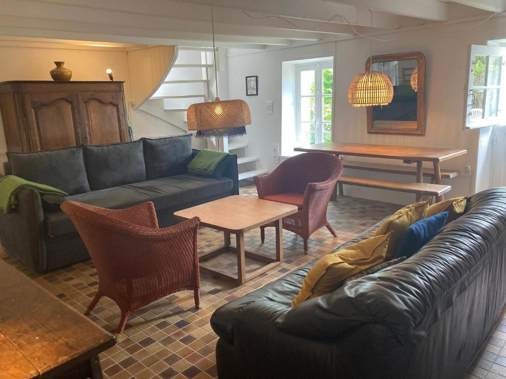 a living room with a couch and chairs and a table at Maison cosy à Locmaria, 6 pers, 1 km plage, grand jardin, animaux ok - FR-1-418-256 in Locmaria