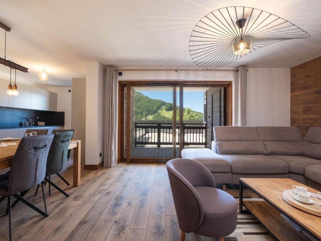 un salon avec un canapé et une table dans l'établissement Appartement Familial au Centre de Courchevel Moriond avec Parking et Balcon - FR-1-563-156, à Courchevel