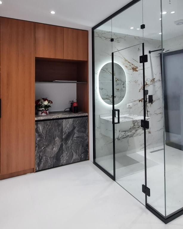 a bathroom with a glass shower and a toilet at Platinum INN The City in Vlorë