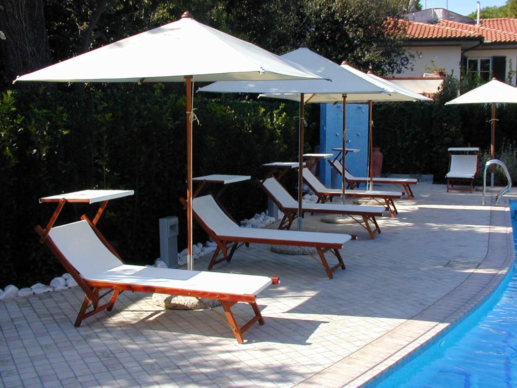 a group of chairs and umbrellas next to a pool at Hotel Bristol in Tirrenia