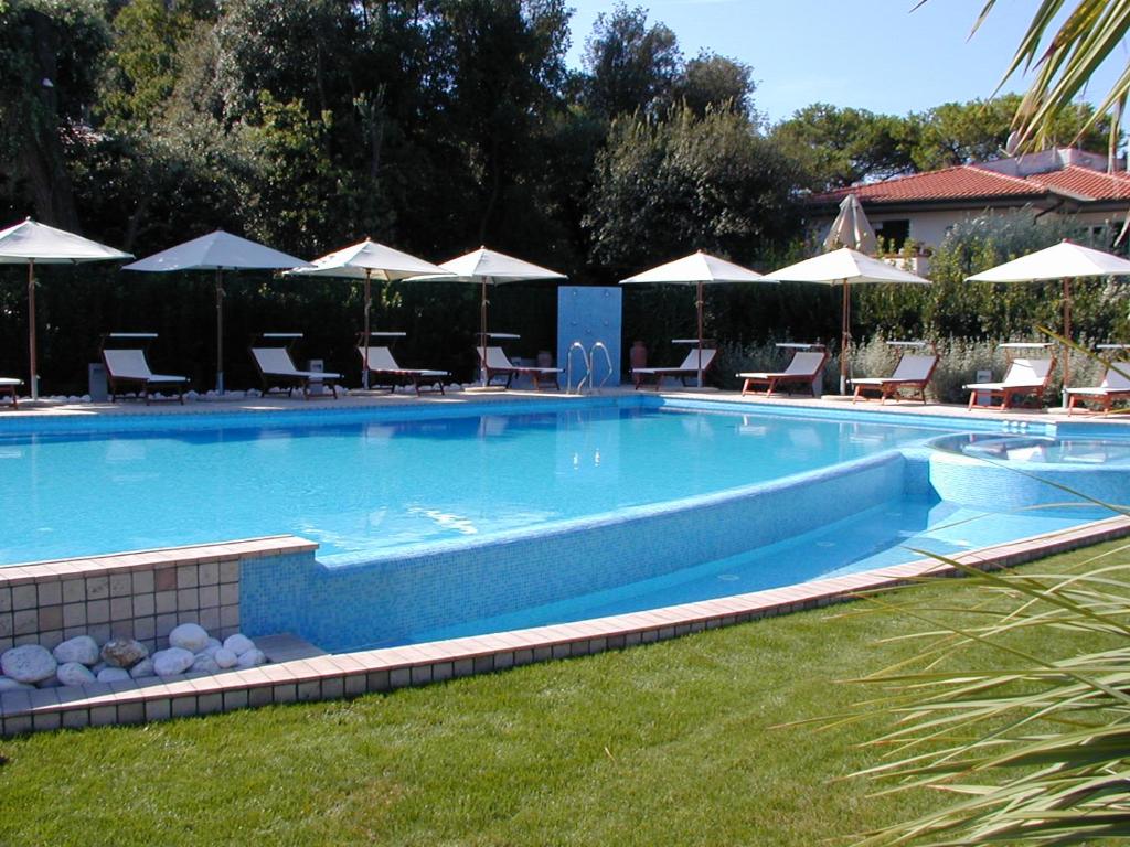 a large swimming pool with chairs and umbrellas at Hotel Bristol in Tirrenia