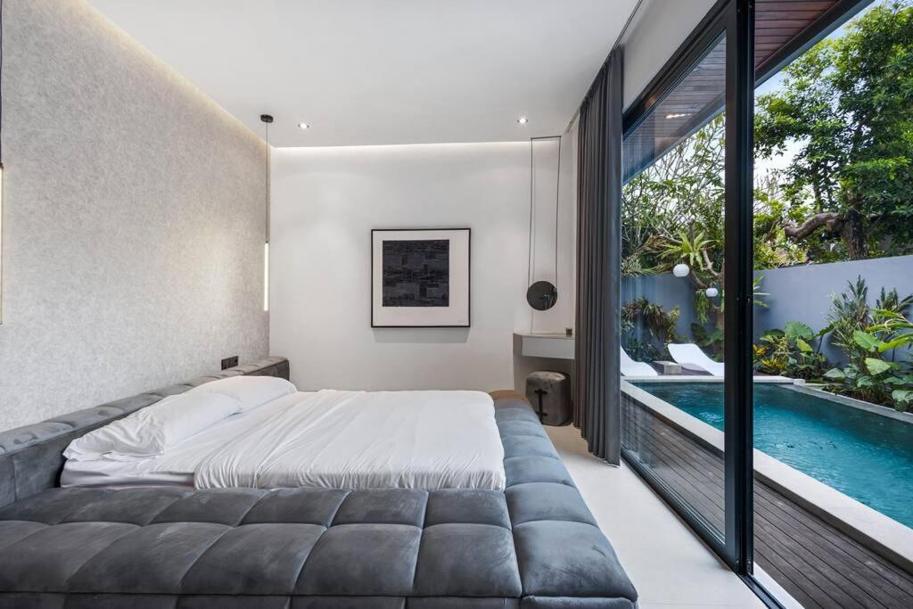 - une chambre avec un lit et une piscine dans l'établissement Luxurious 2 Bedroom Villa Noir, à Canggu
