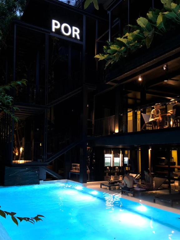 The pool courtyard glowing beneath the hotel’s illuminated POR sign.