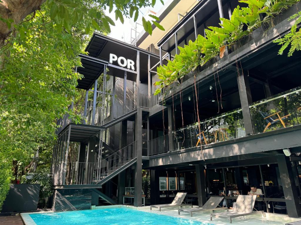 a building with a pool in front of it at POR Santitham in Chiang Mai